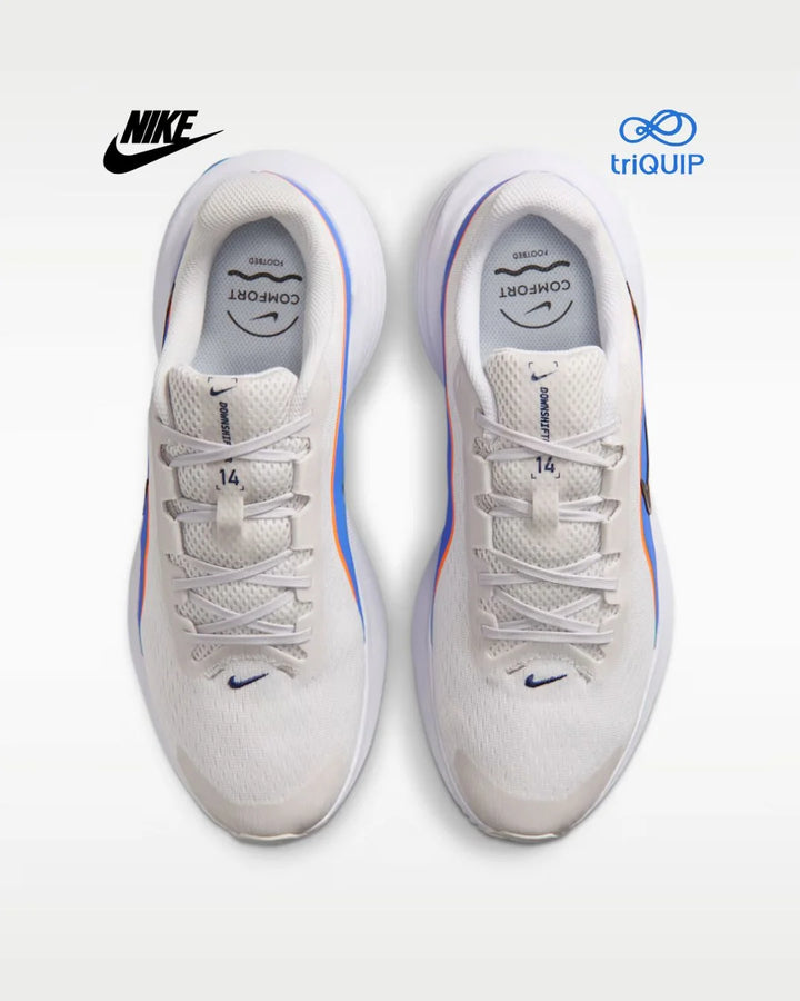 A pair of Nike running shoes in white, shown from a top-down view on a light gray background. The shoes feature blue and orange accents along the side and a blue Nike Swoosh near the toe.