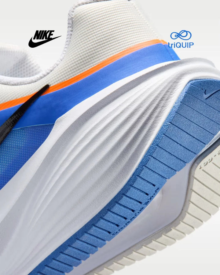 Close-up of a Nike running shoe showing the midsole, heel, and outsole in white, blue, and orange, with Nike and Triquip logos visible.